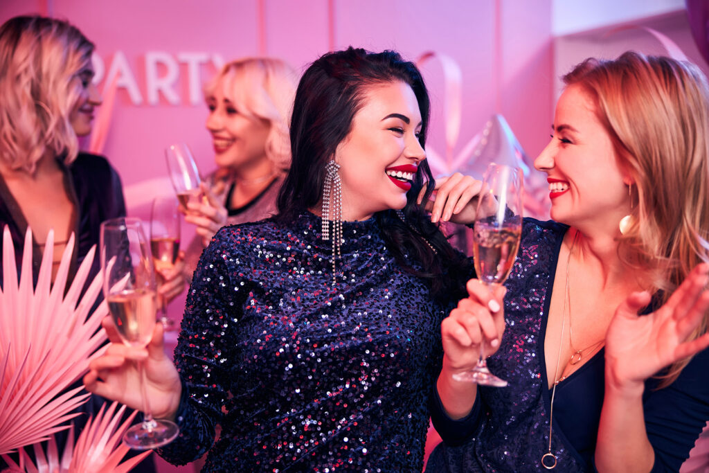 Cheerful well-dressed ladies enjoying their office party